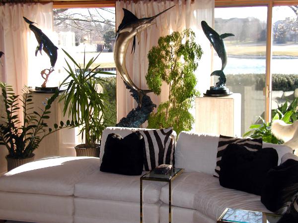 Sala decorada com plantas e sofÃ¡  branco